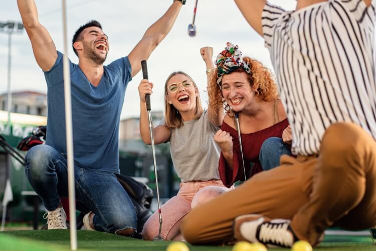 A group of friends enjoying mini golf.