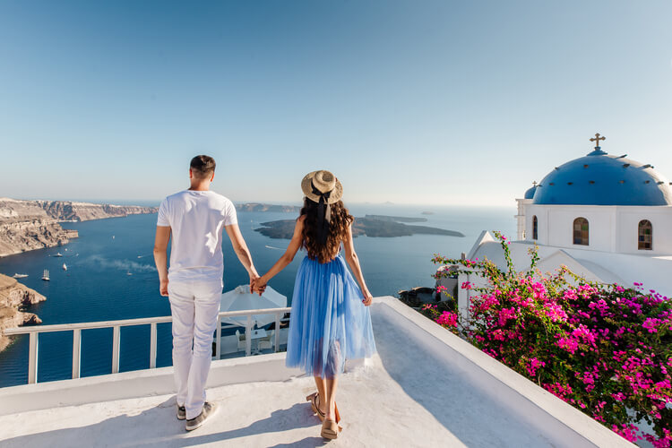 A couple holding hands overlooking Santorini