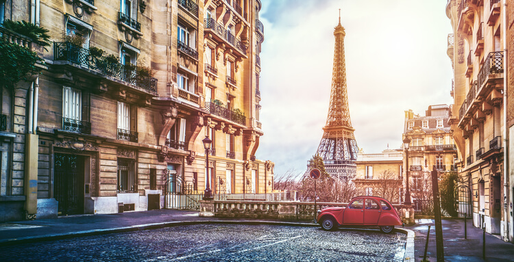 Softly lit streets of Paris with views of the Eiffel Tower and VW Beetle Car