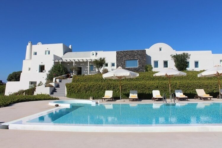 Huge white villa with vast shrub forest, 5 sun loungers and a large pool in the foreground