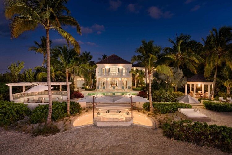A coral house at night surrounded by the palm of your hand.